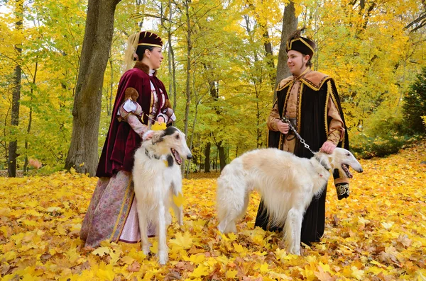 Paar in mittelalterlichen Kostümen mit zwei Barsoi-Hunden — Stockfoto