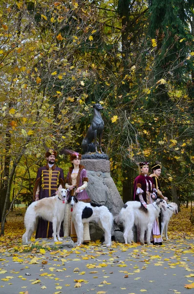 Пари в традиційних середньовічних костюмах з wolfhounds собаками Ліцензійні Стокові Зображення