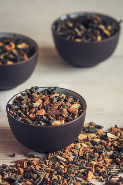 Tè esotico secco con spezie in tazze di porcellana scura — Foto Stock