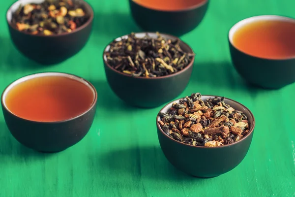Chá exótico seco com especiarias em copos de porcelana escura — Fotografia de Stock