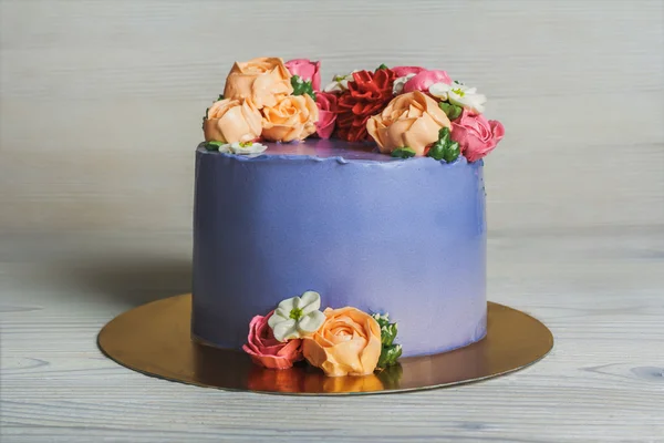 Fioletowy ciasto z kremowymi kwiatkami — Zdjęcie stockowe