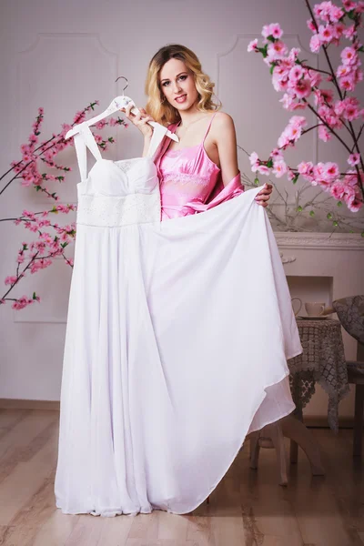 Blond beautiful woman holds her wedding dress — Stock Photo, Image