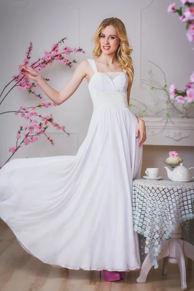 Blond beautiful bride stands near the table — Stock Photo, Image