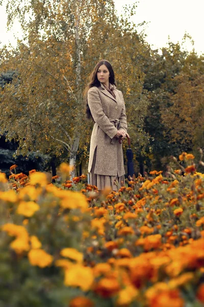 Kvinnan promenader i parken hösten med paraply — Stockfoto
