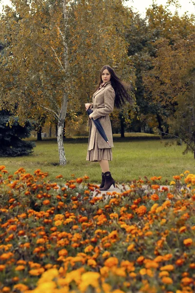 Woman walking in the autumn park with umbrella — Stock Photo, Image