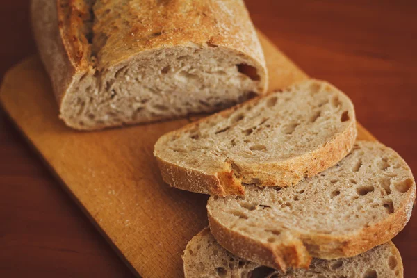 Chléb na tmavé dřevěné pozadí — Stock fotografie