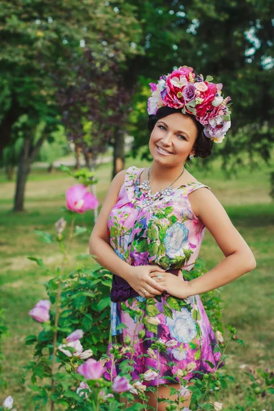 Mladá atraktivní žena s korunkou květin — Stock fotografie