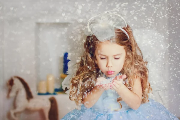 Little angel in light blue dress blowing snow — Stock Photo, Image