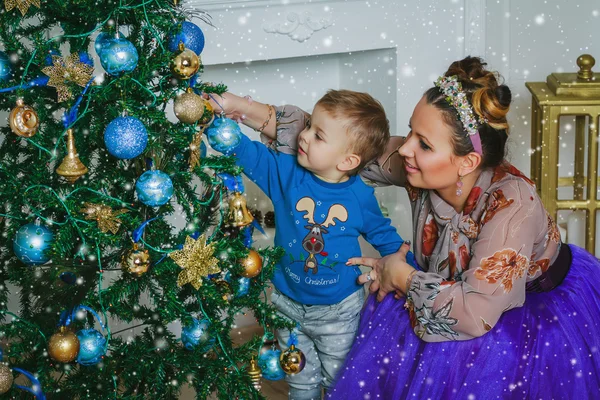 Mother and her sun decorate the new year tree — Stock Photo, Image