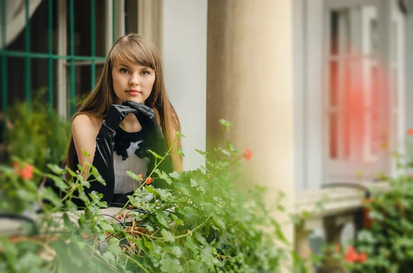 Portrait of beautiful young woman in white dress with black rose — Stock Photo, Image