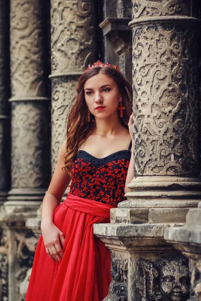 Mooie jonge vrouw in rode jurk met een korset — Stockfoto