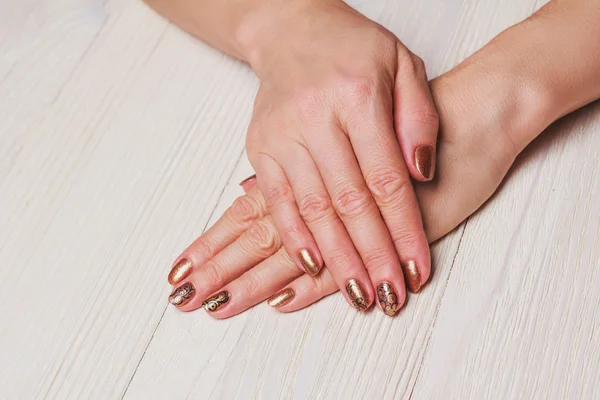 Arte de uñas de oro con remolinos pintados de negro —  Fotos de Stock