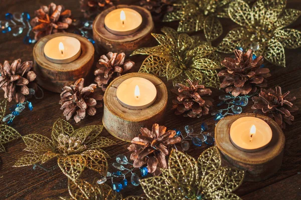 Kerstdecoratie: brandende kaarsen, kegels en gouden bloemen op — Stockfoto