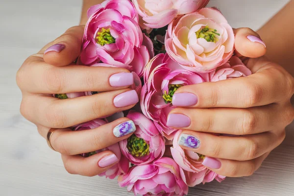Arte de unhas lilás com flores impressas em fundo claro — Fotografia de Stock