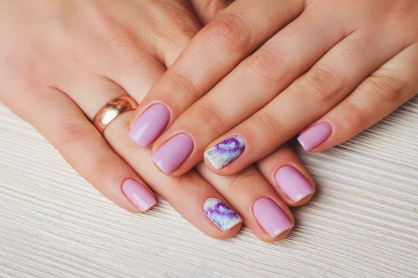 Lilac nail art with printed flowers on light background