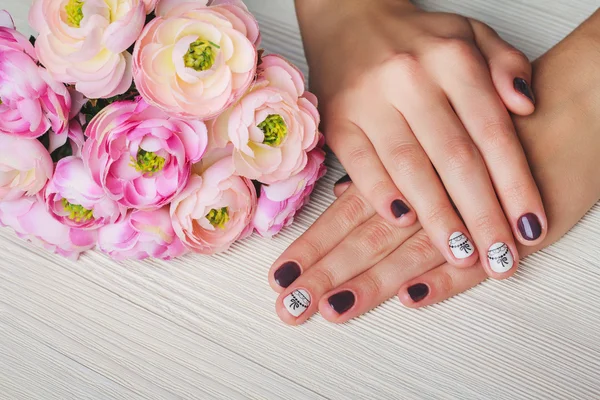 Violet nail art with printed white bow — Zdjęcie stockowe