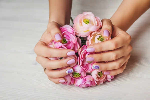 Lilac nail art with printed flowers on light background 로열티 프리 스톡 이미지