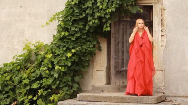 Красива молода жінка в модному червоному платті позує — стокове відео