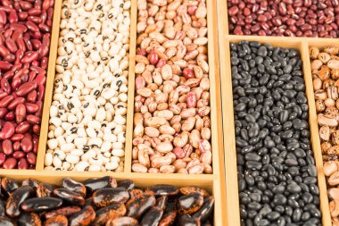 Tahta kutuda farklı fasulyeler var. Borlotti, siyah gözlü, adzuki, kırmızı koşucu, siyah kaplumbağa, kırmızı böbrek.