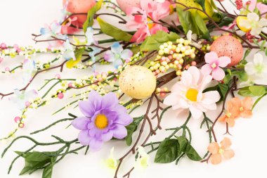 Beyaz arka planda Paskalya yumurtaları ve çiçekler.