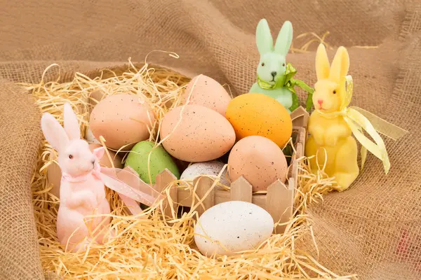 Easter Colorful Eggs Wooden Box Three Bunnies Straw Burlap Background — Stock Photo, Image