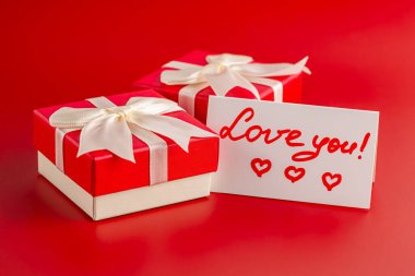 İki Sevgililer Günü hediye kutusu, kırmızı arka planda 