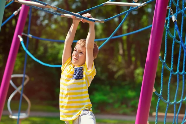 Garçon heureux jouant à l'aire de jeux en été — Photo
