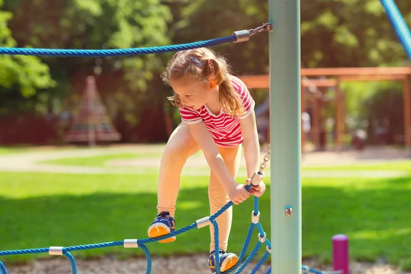 Menina brincando no playground no summe — Fotografia de Stock