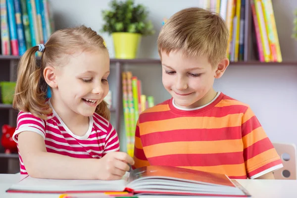 Två glada syskon läser intressanta bok — Stockfoto