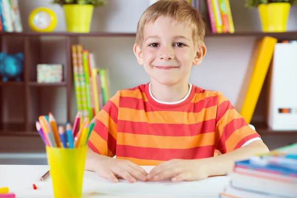 Menino da escola em sala de aula fazendo trabalhos escolares — Fotografia de Stock