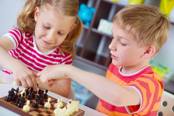 Dos lindos niños trenzando ajedrez — Foto de Stock