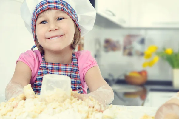 Roztomilá holčička v zástěře pečení cukroví — Stock fotografie