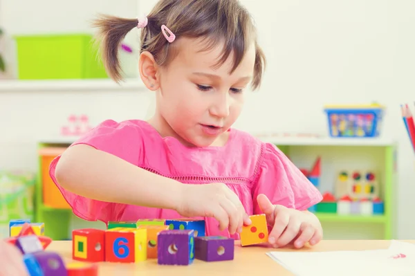 Meisje, spelen met speelgoed bakstenen op school — Stockfoto