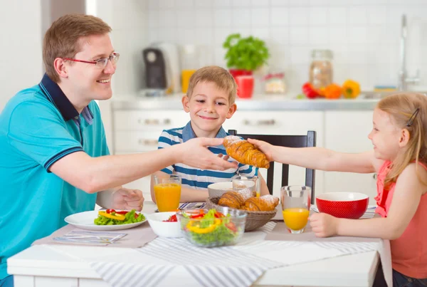 Sorrindo família tomando café da manhã na cozinha — Fotografia de Stock