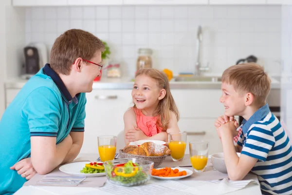 Sorrindo família tomando café da manhã na cozinha — Fotografia de Stock