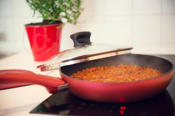 Vegetarian lentil bolognese sauce in a frying pan on a dark stov — Stock Photo, Image