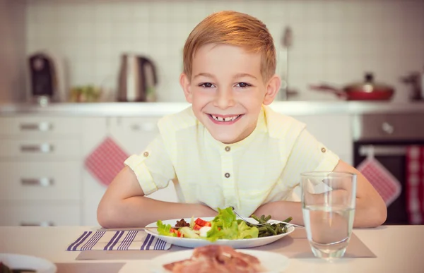 Joven niño feliz diligente en una mesa comiendo comida saludable con Cu —  Fotos de Stock