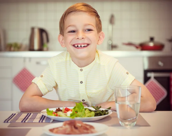 Jovem menino feliz diligente em uma mesa comer refeição saudável com cu — Fotografia de Stock