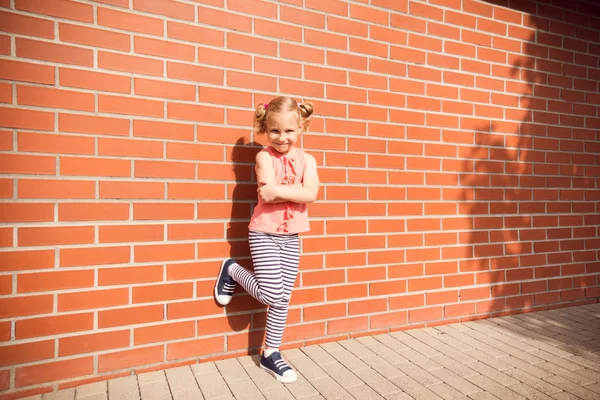 Retrato de niña riéndose de ladrillos fondo de la pared — Foto de Stock