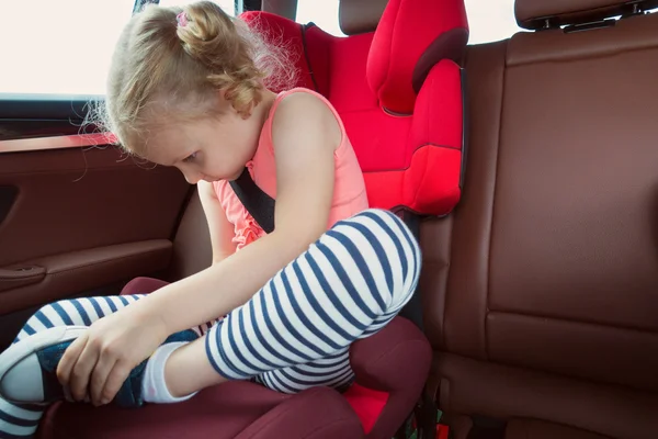 Porträtt av glad liten barn flicka sitter bekvämt i bil s — Stockfoto