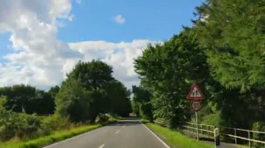 Yeşil ve temiz kırsalda hareket eden bir arabanın ön camından ateş edilmiş.