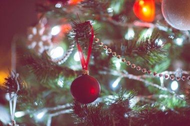 Toplarla süslenmiş Noel ağacının yakın fotoğrafını çek. Karanlıkta kırmızı kalpler, ama yılbaşı arifesinde yılbaşı ışıkları.