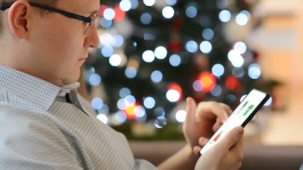 Young Man Browsing Online Store His Smartphone Looking Christmas Presents — Stock Video