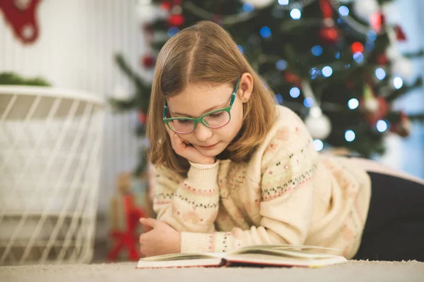 Portrét Krásné Holčičky Čtení Knihy Sedí Blízkosti Zdobené Vánoční Stromeček — Stock fotografie