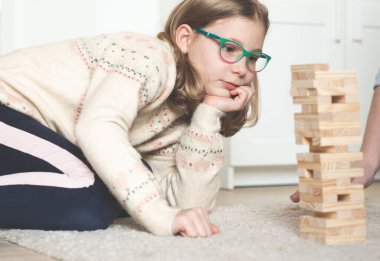 Mutlu genç baba evde tahta bloklarla sevimli kızıyla oynuyor.