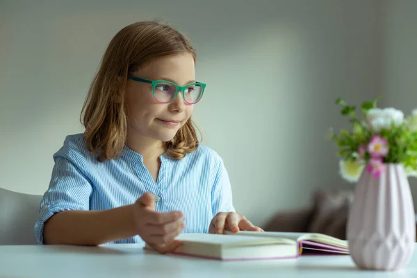 幸せなかなりティーン女の子読書本にデスクで自宅でパンデミックの距離学習中 — ストック写真