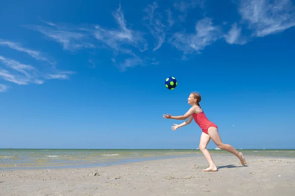 여름날 해변에서 귀여운 소녀가 놀면서 공놀이를 재미있게 — 스톡 사진