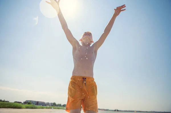 在夏日阳光明媚的背景下 少年在沙滩上打篮球的形象 — 图库照片