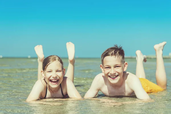 Retrato Dois Irmãos Felizes Crianças Adolescentes Que Mentem Água Praia — Fotografia de Stock