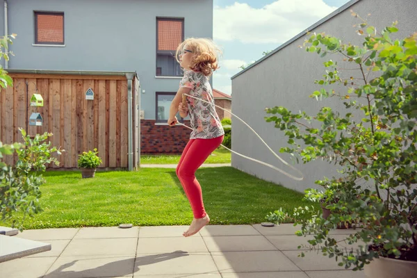 Niña Feliz Saltando Con Cuerda Patio Trasero Día Soleado Mientras — Foto de Stock